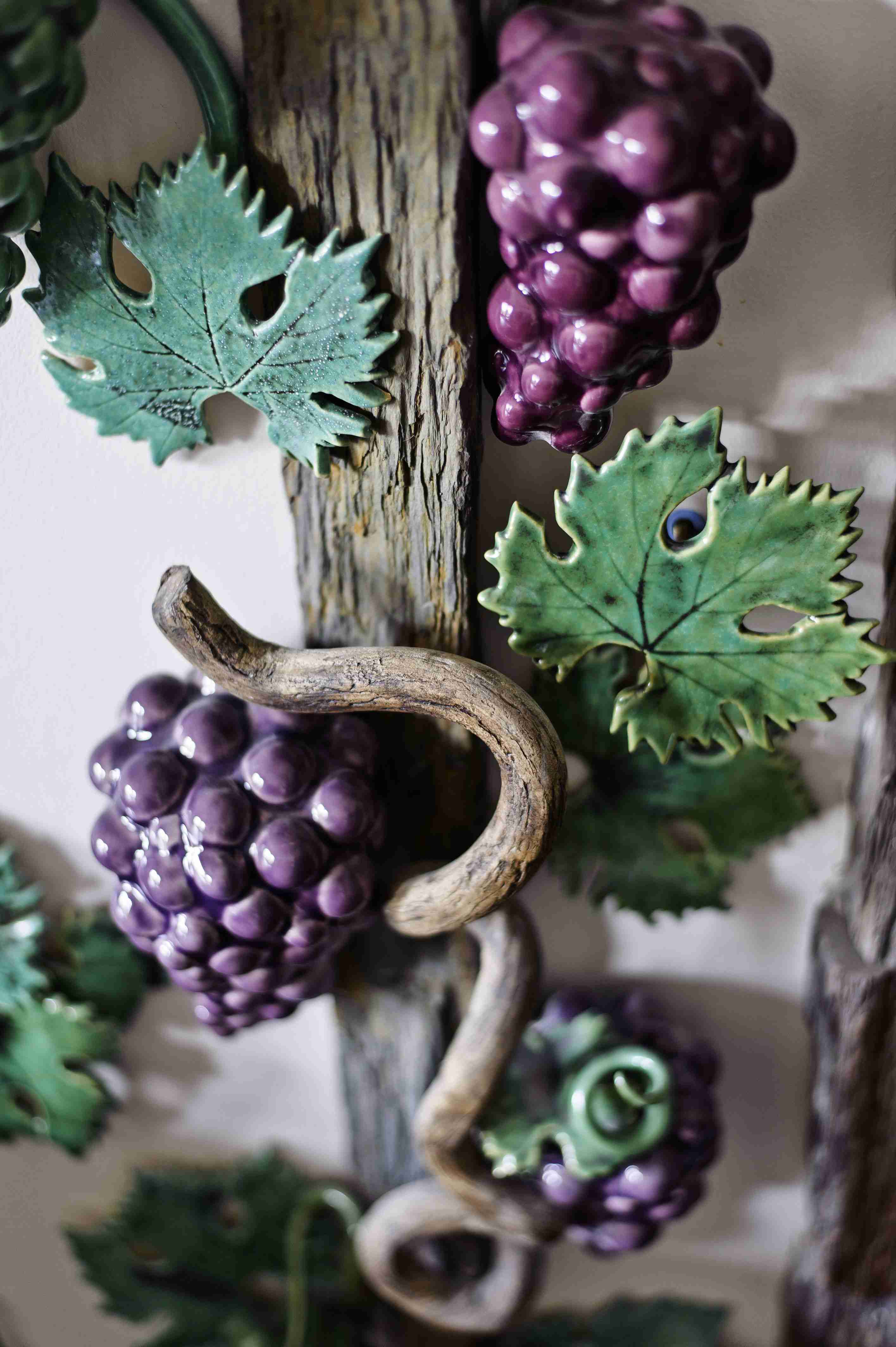 Felfutó kerámiainda szőlőfürtökkel és levelekkel.
